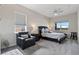 Well-lit bedroom with a dark wood frame bed, an accent chair, and windows offering natural light at 4228 Sunset Preserve Blvd, Orlando, FL 32820