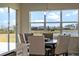 Dining area showcasing a wooden table and upholstered chairs bathed in natural light from a large window with scenic views at 4228 Sunset Preserve Blvd, Orlando, FL 32820