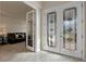 Elegant foyer featuring glass-paneled double doors, wood-look tile flooring, and a glimpse into the living room at 4228 Sunset Preserve Blvd, Orlando, FL 32820