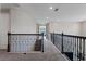 Upstairs hallway with neutral walls and dark wood and wrought iron banister at 4228 Sunset Preserve Blvd, Orlando, FL 32820