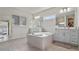 An exquisite primary bath includes a large soaking tub and dual vanities at 4228 Sunset Preserve Blvd, Orlando, FL 32820