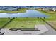 Spacious lawn and beautiful water view for this lot with solar panels on house in background at 4228 Sunset Preserve Blvd, Orlando, FL 32820