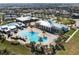 Aerial view showcasing a luxurious resort-style pool with palm trees, lounge chairs, and a spacious clubhouse at 4909 Drawdy Ct, St Cloud, FL 34772