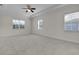 Large, bright bedroom with plush carpeting, three large windows, and a ceiling fan at 4909 Drawdy Ct, St Cloud, FL 34772