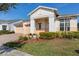 Inviting front exterior featuring a three-car garage, mature landscaping, and a covered entryway at 4909 Drawdy Ct, St Cloud, FL 34772