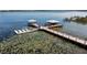 Picturesque lake pier featuring boat slips and covered seating areas amidst calm waters and lily pads at 4909 Drawdy Ct, St Cloud, FL 34772