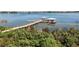 Scenic lake view with a wooden pier, boat slips, and lush greenery along the shoreline at 4909 Drawdy Ct, St Cloud, FL 34772