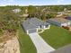 Aerial view of a modern home with a well-maintained lawn and a long driveway at 505 St Johns Ct, Kissimmee, FL 34759