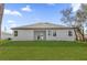 Rear exterior view of home showcasing white siding, gray roof, and green lawn at 505 St Johns Ct, Kissimmee, FL 34759