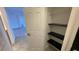 Hallway closet with black shelves, light flooring, and a glimpse of a living space at 5526 G Nw Ave # 4915, Orlando, FL 32815