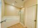 Bathroom featuring a soaking tub with tile surround and glass enclosed shower at 561 Telfair Square Ct, Sanford, FL 32771