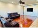 Bright living room with hardwood floors, ceiling fan, and comfortable leather sofas at 561 Telfair Square Ct, Sanford, FL 32771