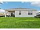 Home exterior featuring a well-manicured lawn, covered patio, and lush surrounding greenery at 5929 Cliffbow Loop, Leesburg, FL 34748