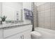 Bathroom featuring a granite sink, a tiled shower-tub combo, and a white vanity at 5929 Cliffbow Loop, Leesburg, FL 34748