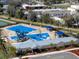 Aerial view of a community pool with water slides, splash pad, and covered picnic areas at 5929 Cliffbow Loop, Leesburg, FL 34748