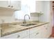 Bright kitchen featuring white cabinetry, granite countertops, and stainless steel faucet at 630 Carpenter Rd, Orlando, FL 32833