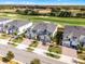 A detailed aerial view shows modern townhomes with manicured lawns near a lush golf course at 635 Ocean Course Ave # 635, Champions Gate, FL 33896