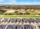 An aerial view shows homes near a golf course with lush green fairways and sand traps on a sunny day at 635 Ocean Course Ave # 635, Champions Gate, FL 33896