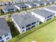 Aerial view showcases backyard with black fence, screened-in balconies, and neighborhood at 635 Ocean Course Ave # 635, Champions Gate, FL 33896