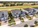 A detailed aerial view shows modern townhomes with manicured lawns near a lush golf course at 635 Ocean Course Ave # 635, Champions Gate, FL 33896