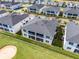 Back exterior aerial view featuring screened patios/balconies, and black metal fence, and nearby golf sand trap at 635 Ocean Course Ave # 635, Champions Gate, FL 33896