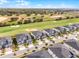 A detailed aerial view shows modern townhomes with manicured lawns and a lush green golf course at 635 Ocean Course Ave # 635, Champions Gate, FL 33896