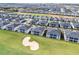 An aerial view shows a residential community surrounding a golf course and sand trap at 635 Ocean Course Ave # 635, Champions Gate, FL 33896