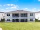 Exterior rear view features a lawn, black metal fence and screened in patios and balconies at 635 Ocean Course Ave # 635, Champions Gate, FL 33896