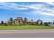 A view of the Oasis Clubhouse featuring manicured lawns and palm trees on a clear day at 635 Ocean Course Ave # 635, Champions Gate, FL 33896