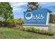 A close-up of the 'Oasis Clubhouse at ChampionsGate' sign, surrounded by landscaping and a blue sky at 635 Ocean Course Ave # 635, Champions Gate, FL 33896