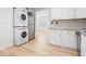 Modern laundry area featuring stacked washer/dryer and access to kitchen at 640 Robinhood Dr # B, Maitland, FL 32751