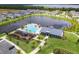 Aerial view of a community pool, playground, and clubhouse set alongside a scenic lake at 652 Kimber Ln, Debary, FL 32713