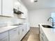 Stylish kitchen with white cabinets, stainless steel range hood, an island sink, and wood-look floors at 652 Kimber Ln, Debary, FL 32713