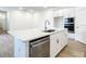 Modern kitchen featuring a large island with a sink and dishwasher, stainless steel appliances, and sleek white cabinetry at 652 Kimber Ln, Debary, FL 32713