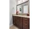 Modern bathroom with granite countertops, dark cabinetry, and a large mirror at 8774 Bayview Crossing Dr, Winter Garden, FL 34787