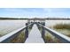 Long dock with a covered seating area at the end, surrounded by lily pads at 8774 Bayview Crossing Dr, Winter Garden, FL 34787