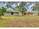 View of backyard with grassy lawn and mature landscaping at 912 Enterprise Ave, New Smyrna Beach, FL 32168