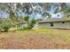 View of backyard with grassy lawn and mature landscaping at 912 Enterprise Ave, New Smyrna Beach, FL 32168