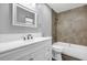 Bathroom with a double sink vanity, white cabinets, and tiled shower at 912 Enterprise Ave, New Smyrna Beach, FL 32168