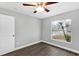 This bedroom features wood-look flooring, a ceiling fan and a window with outside view at 912 Enterprise Ave, New Smyrna Beach, FL 32168