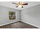 Bedroom with ceiling fan, gray walls, and window overlooking yard at 912 Enterprise Ave, New Smyrna Beach, FL 32168