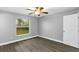 Bedroom with gray wood-look floors, ceiling fan, and bright window at 912 Enterprise Ave, New Smyrna Beach, FL 32168