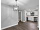 Open-concept dining area featuring modern chandelier and stylish, gray-toned vinyl floors at 912 Enterprise Ave, New Smyrna Beach, FL 32168