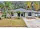 Charming single-story home with a well-manicured lawn and mature palm trees creating curb appeal at 912 Enterprise Ave, New Smyrna Beach, FL 32168