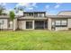 Backyard view of the home's architecture and lush green lawn at 95 Carolwood Blvd, Fern Park, FL 32730