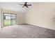 Bright living room with neutral walls, ceiling fan, and sliding glass doors to a patio at 95 Carolwood Blvd, Fern Park, FL 32730