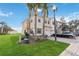 View of a two-story townhouse with a brick paver driveway, well-maintained lawn, and mature landscaping at 3446 Allegra Cir, St Cloud, FL 34772