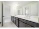 Modern bathroom featuring a double vanity, undermount sinks, and gold hardware, leading into the bedroom at 10055 Brocksport Cir, Gotha, FL 34734