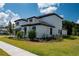 Landscaped side view of a two-story home with a tiled roof at 10055 Brocksport Cir, Gotha, FL 34734