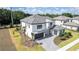 Expansive two-story home featuring a gray tiled roof, a paved driveway and lush landscaping at 10055 Brocksport Cir, Gotha, FL 34734